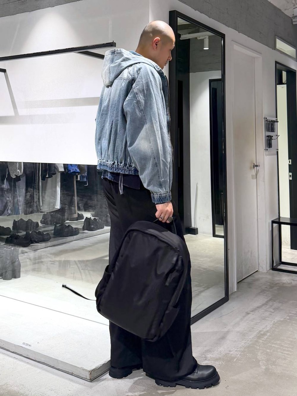 ブルー系のブルゾン、ブラック系のドレスシューズ、ブラック系のバックパック/リュックを着用したメンズの春コーディネートの5枚目の写真