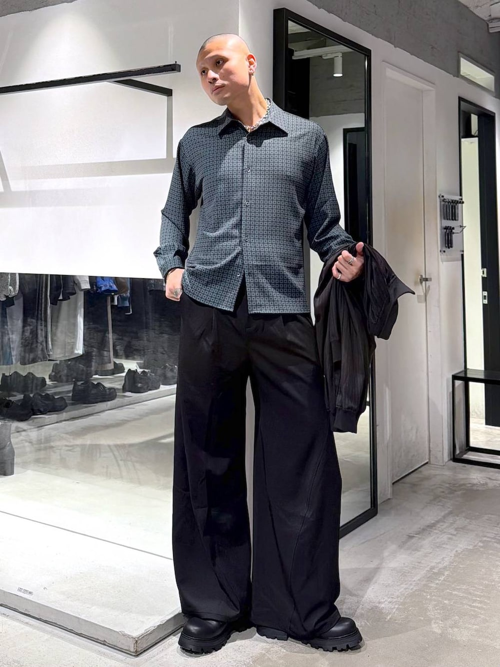 ブラック系のドレスシューズ、ブラック系のスラックス、ブラウン系のその他トップスを着用したメンズの春コーディネートの5枚目の写真