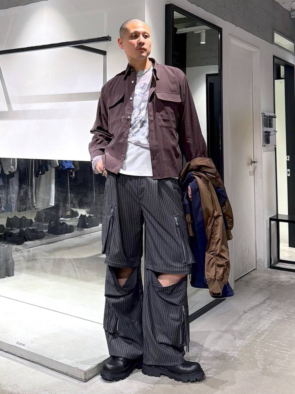 ブラック系のドレスシューズ、グレー系のカーゴパンツ、ブルー系のパーカーを着用したメンズの春コーディネートの5枚目の写真