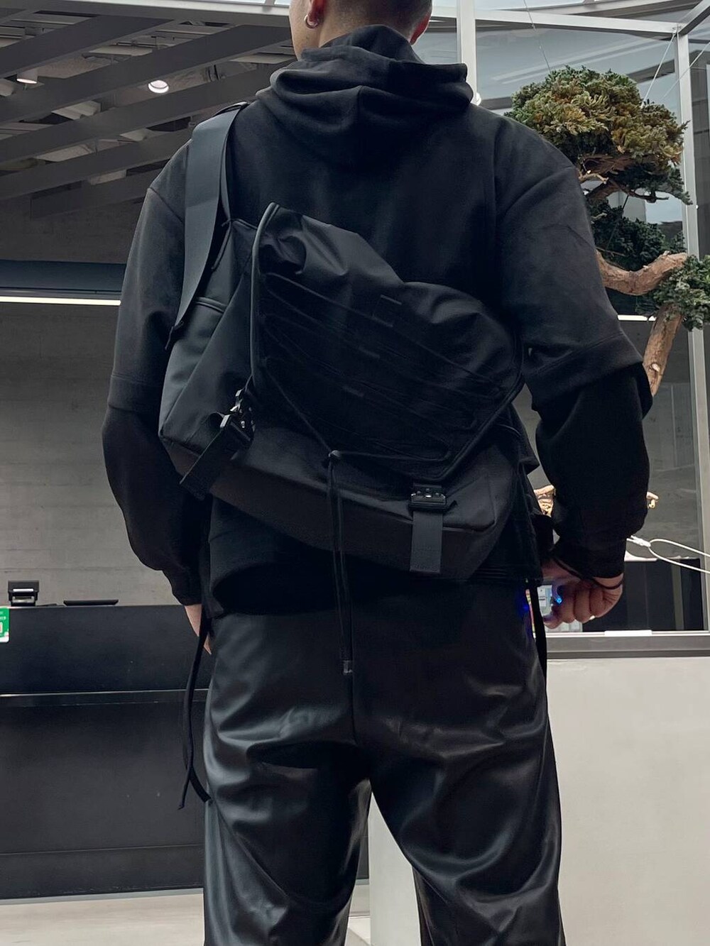 ブラック系のスラックス、ブラック系のメッセンジャーバッグ、ブラック系のドレスシューズを着用したメンズの秋コーディネートの3枚目の写真