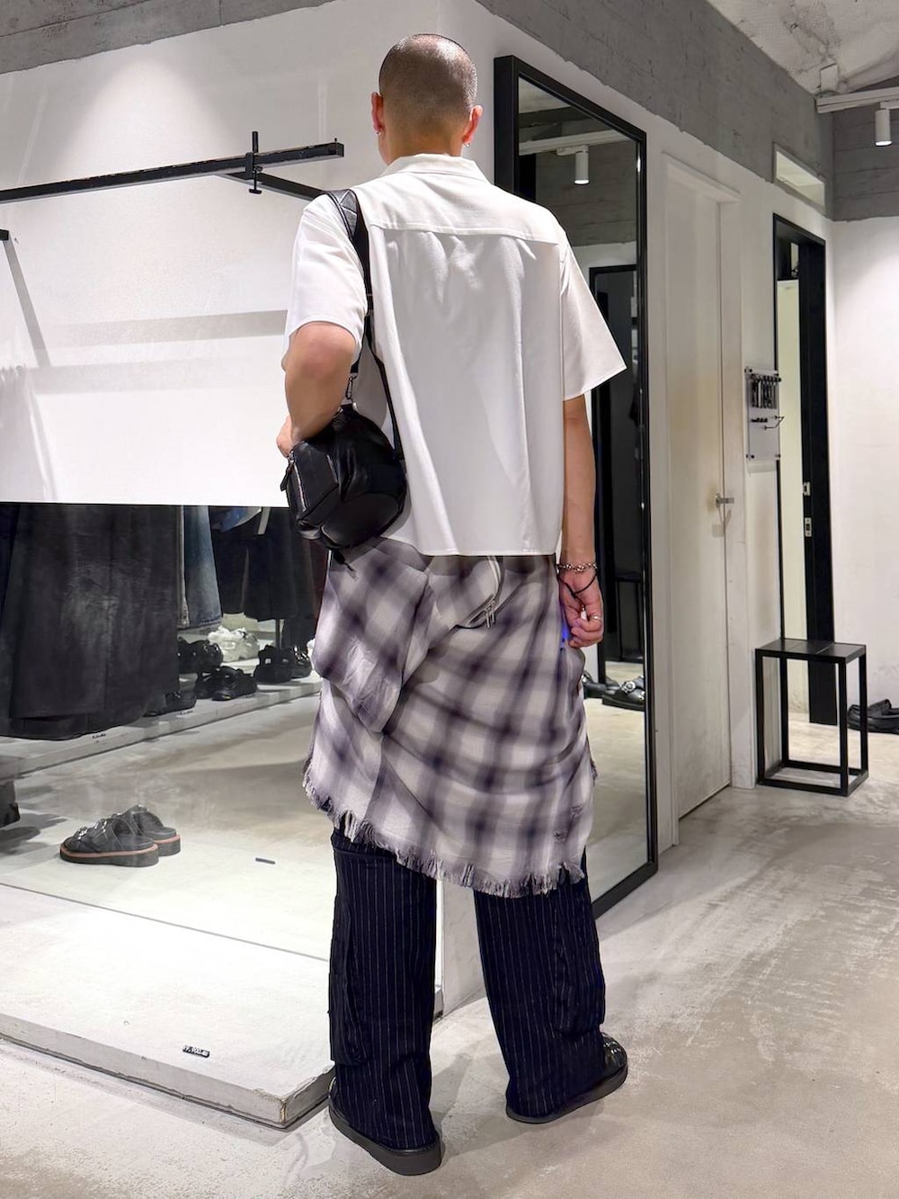 ブラック系のショルダーバッグ、ブラック系のサンダル、ブルー系のカーゴパンツを着用したメンズの夏コーディネートの3枚目の写真