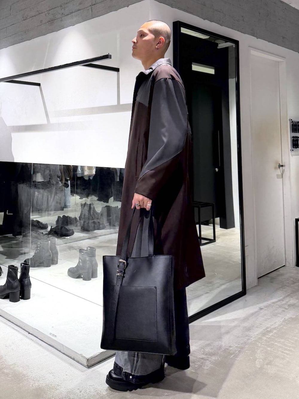 ブルー系のポロシャツ、ブラック系のデニムパンツ、ブラック系のドレスシューズを着用したメンズの春コーディネートの2枚目の写真