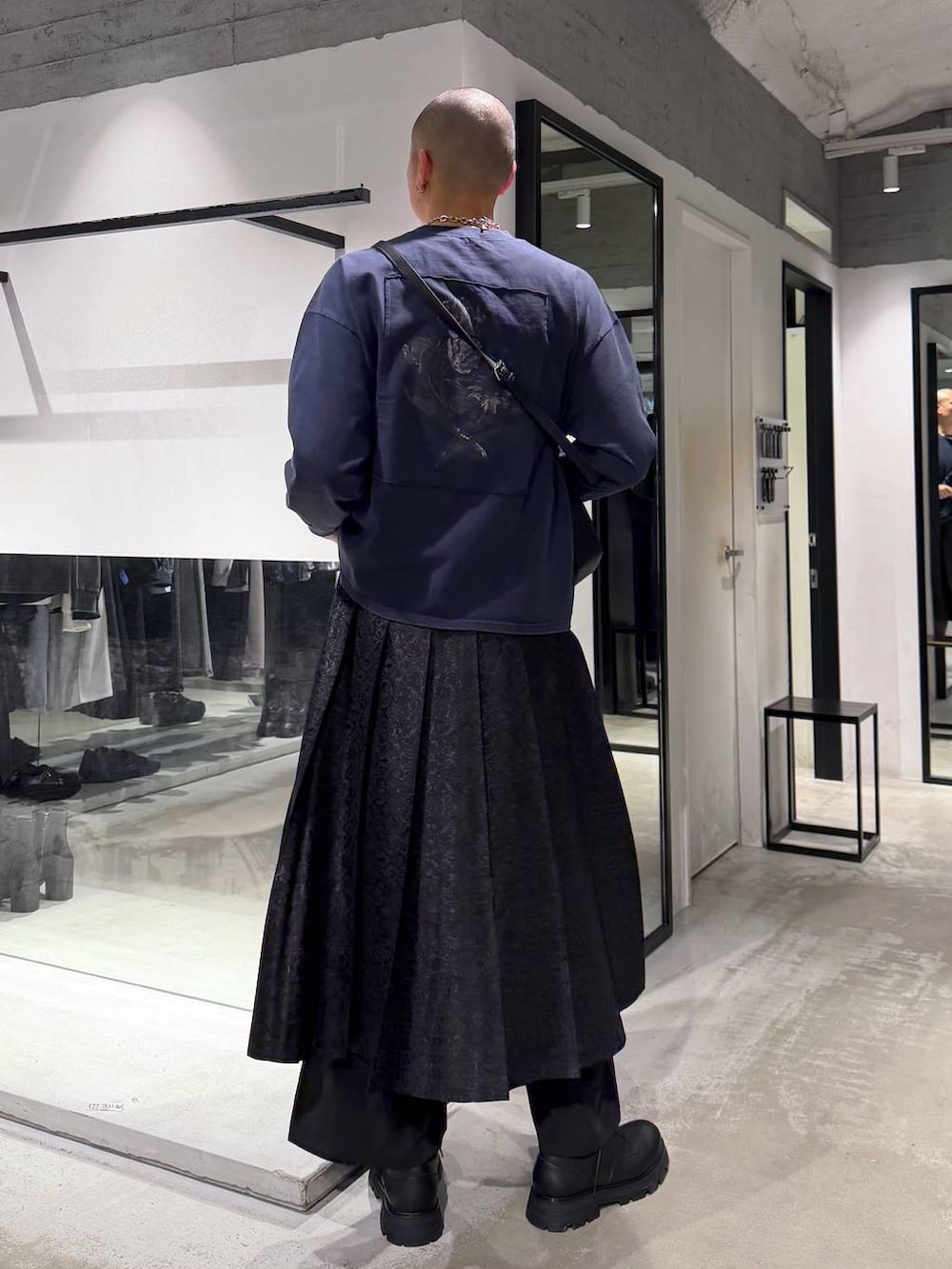 ブラック系のその他パンツ、ブラック系のドレスシューズ、グリーン系のトレンチコートを着用したメンズの春コーディネートの6枚目の写真