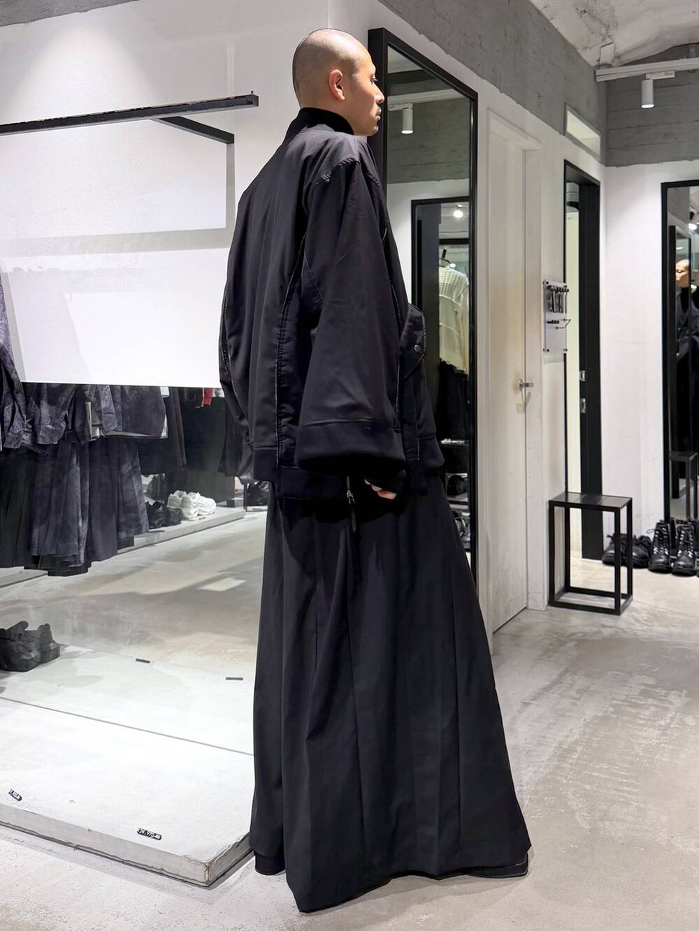 ブラック系のブルゾン、ブラック系のTシャツ/カットソー、ブラック系のブーツを着用したメンズの秋コーディネートの4枚目の写真