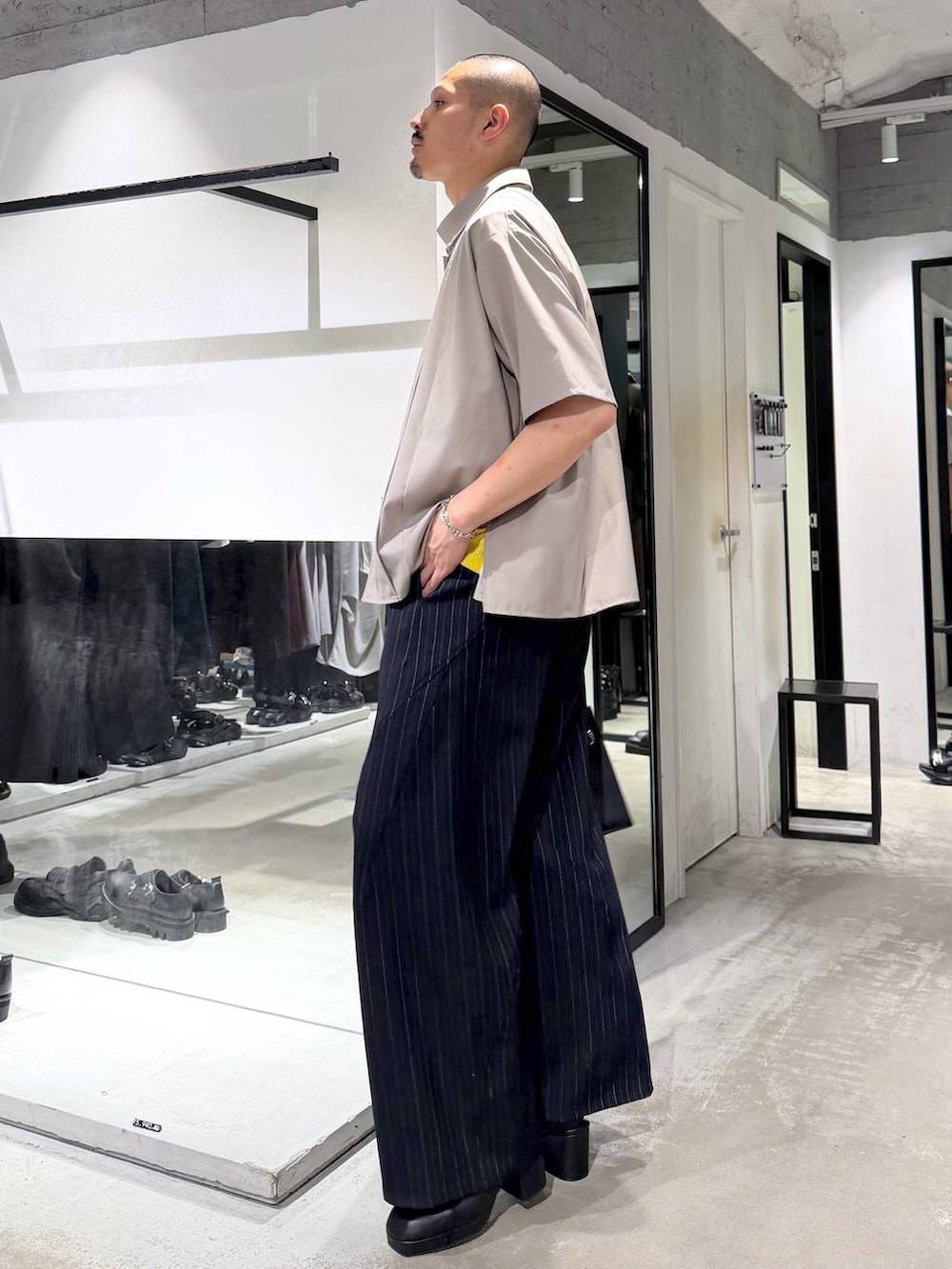 ブラック系のサンダル、ブルー系のスラックス、ベージュ系のシャツ/ブラウスを着用したメンズの夏コーディネートの2枚目の写真