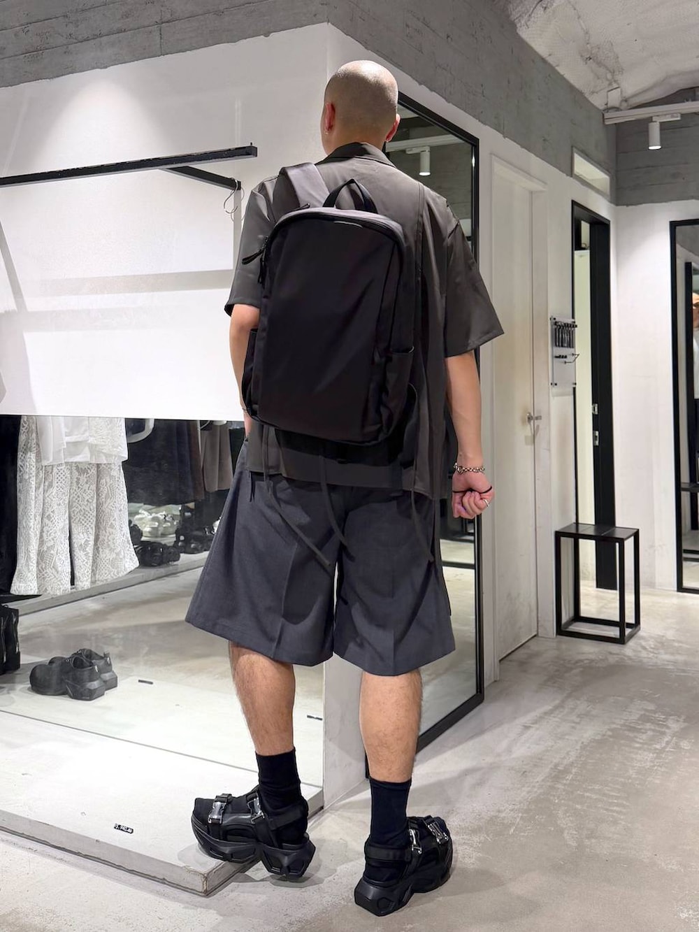 ブラック系のサンダル、ホワイト系のTシャツ/カットソー、ブラック系のバックパック/リュックを着用したメンズの夏コーディネートの3枚目の写真