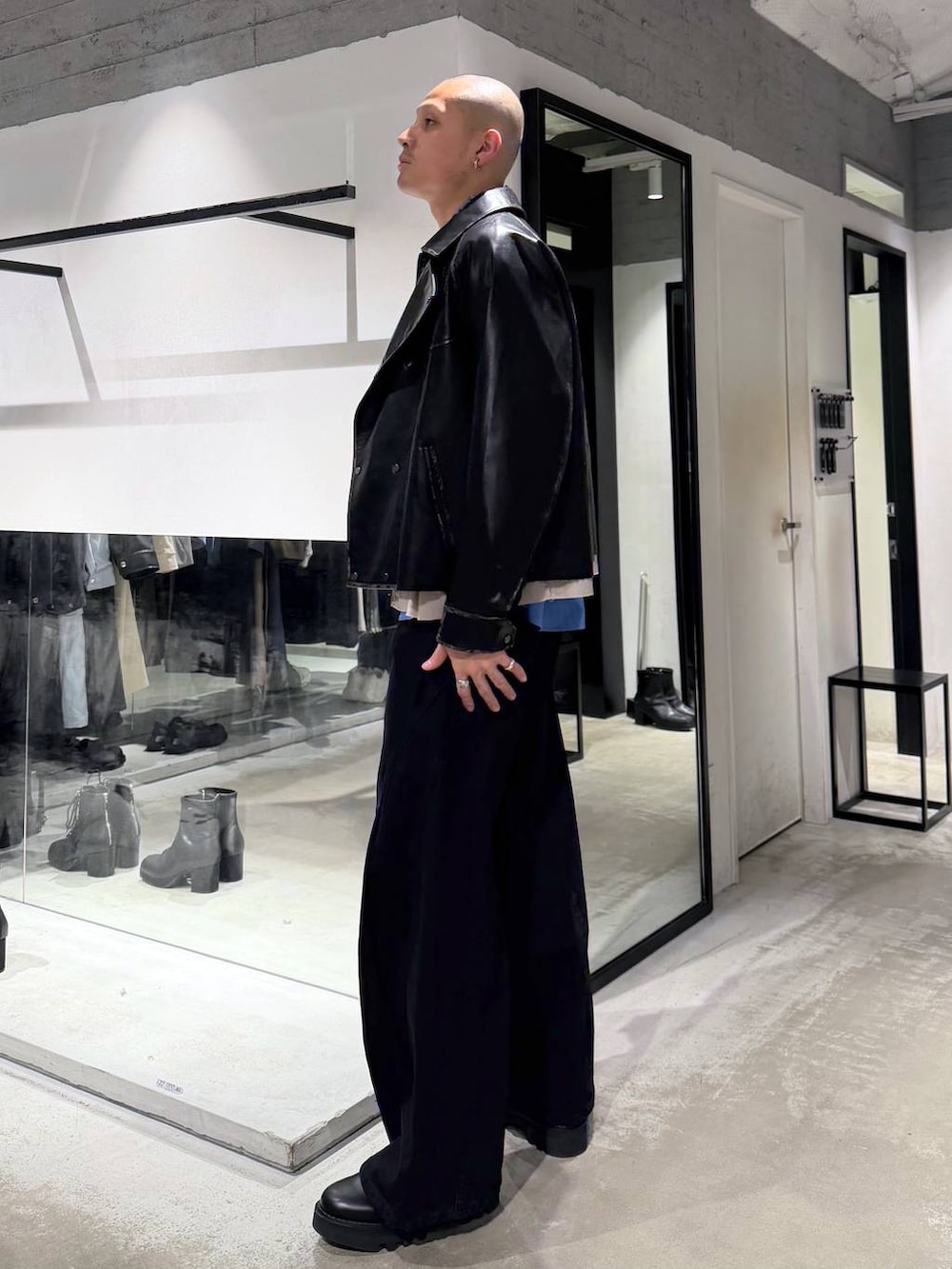 ブルー系のシャツ/ブラウス、ブラック系のドレスシューズ、ブラック系のハンドバッグを着用したメンズの冬コーディネートの2枚目の写真