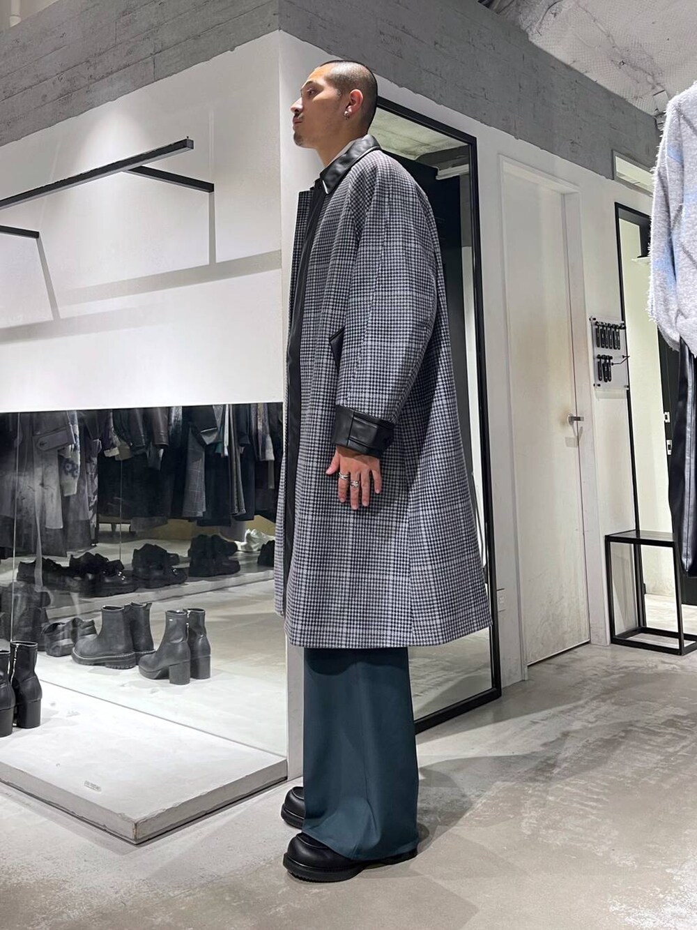 ホワイト系のネクタイ、ベージュ系のステンカラーコート、ブラック系のショルダーバッグを着用したメンズの秋コーディネートの3枚目の写真