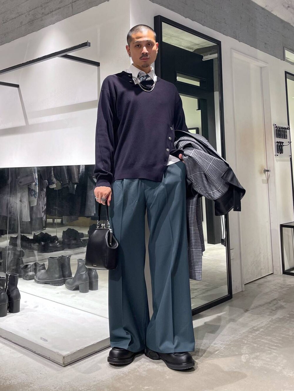 ホワイト系のネクタイ、ベージュ系のステンカラーコート、ブラック系のショルダーバッグを着用したメンズの秋コーディネートの6枚目の写真