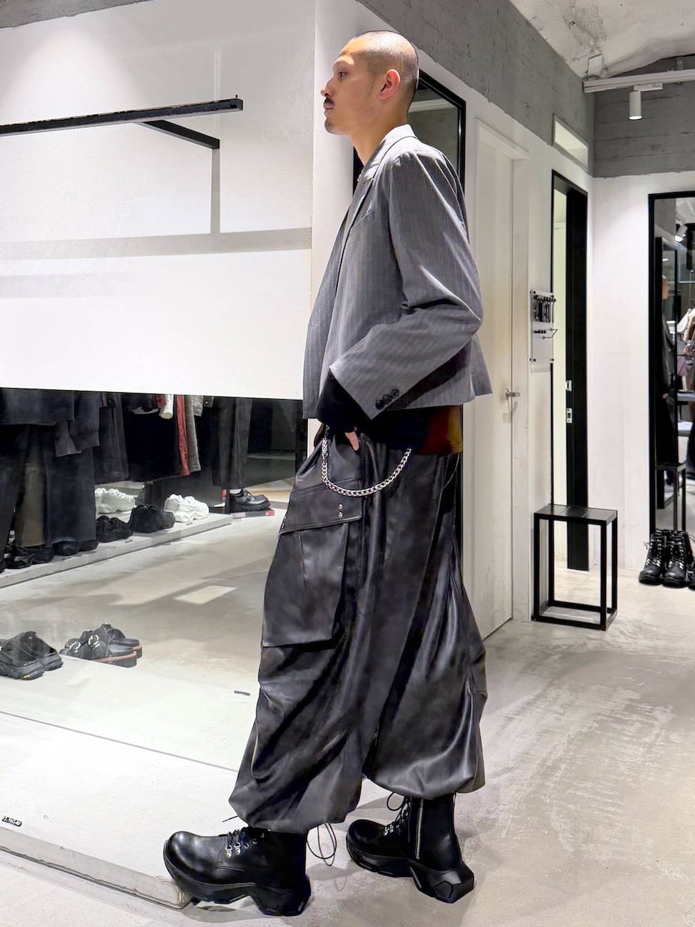 ブラック系のトートバッグ、ブラック系のブーツ、オレンジ系のTシャツ/カットソーを着用したメンズの秋コーディネートの2枚目の写真