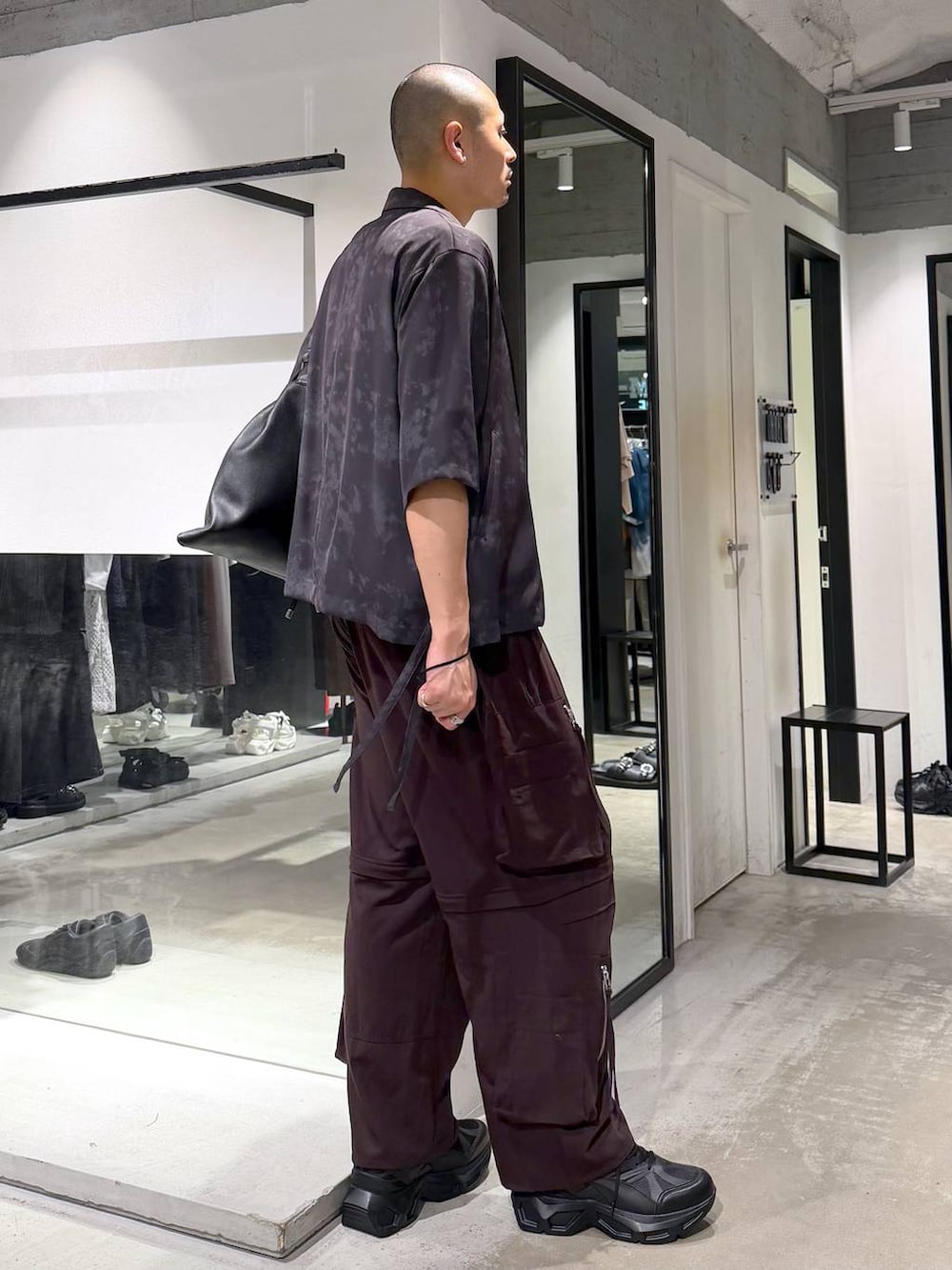 ブラック系のスニーカー、ブラウン系のカーゴパンツ、グレー系のテーラードジャケットを着用したメンズの夏コーディネートの4枚目の写真
