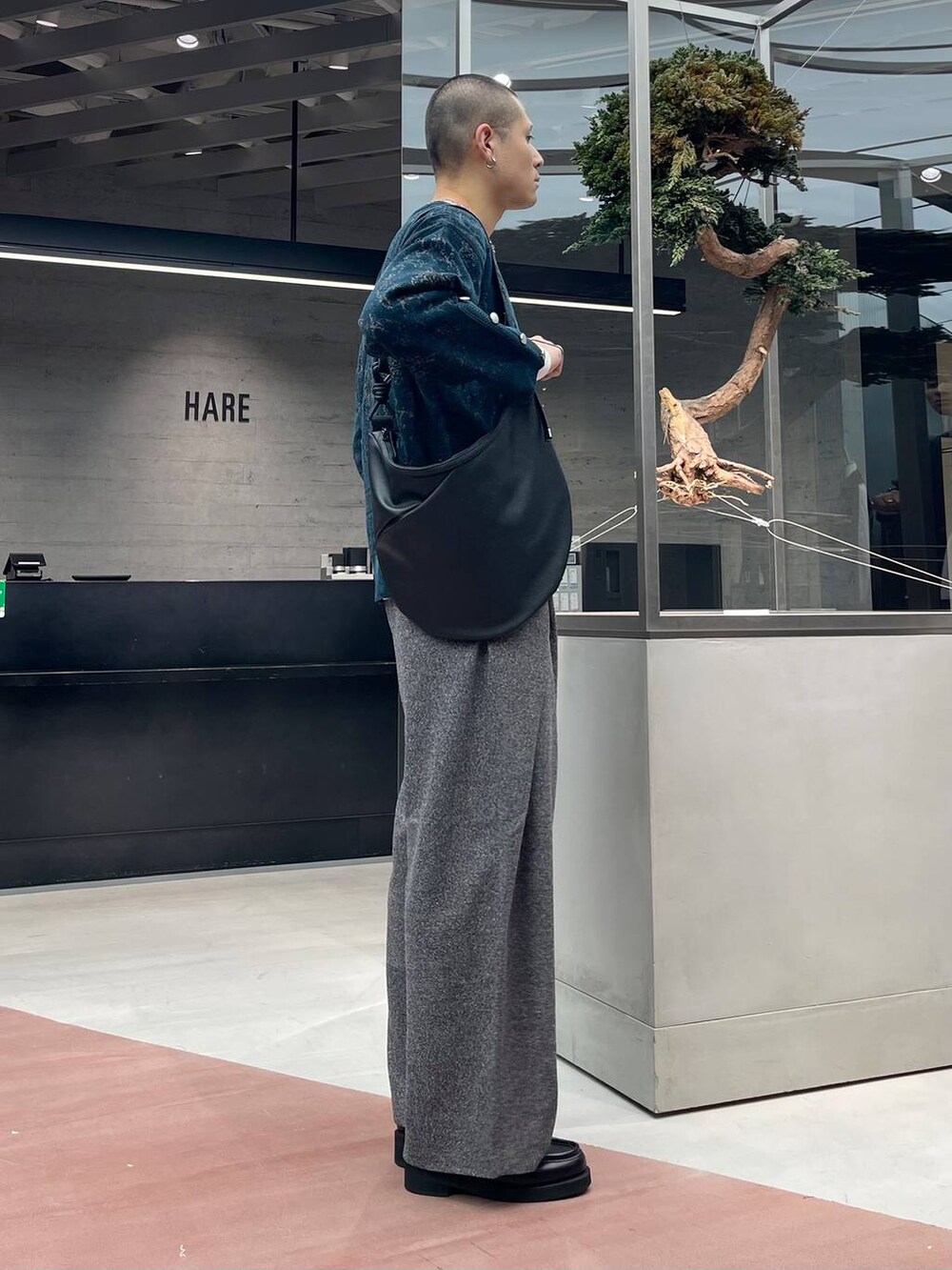 グリーン系のカーディガン/ボレロ、ブラック系のローファー、ブラック系のスラックスを着用したメンズの秋コーディネートの4枚目の写真