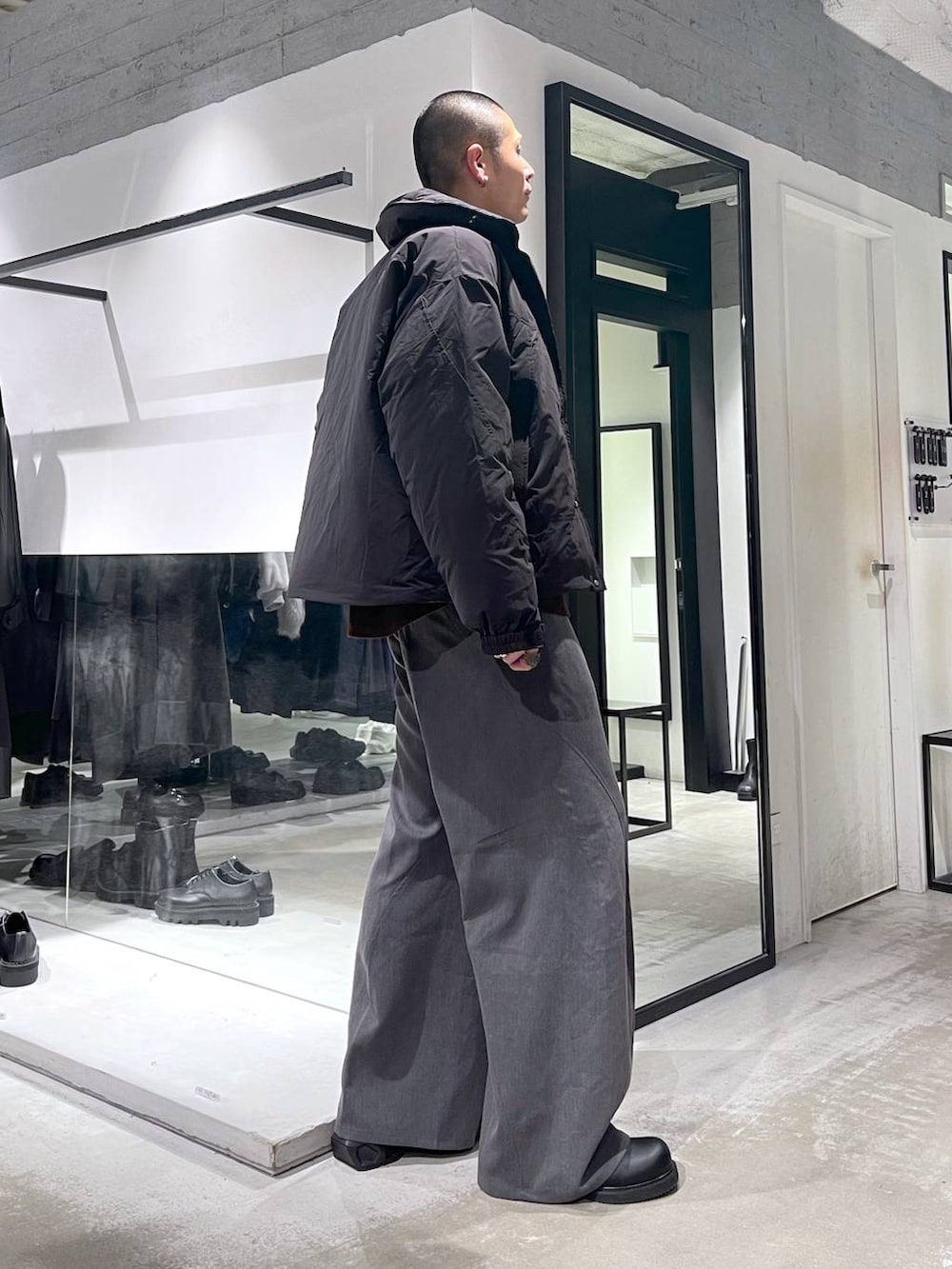 ブラック系のダウンジャケット/コート、グレー系のスラックス、ブラック系のドレスシューズを着用したメンズの冬コーディネートの5枚目の写真
