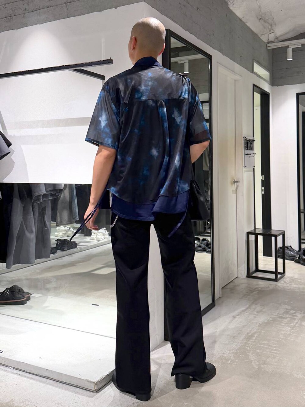 ブラック系のショルダーバッグ、ホワイト系のTシャツ/カットソー、ブラック系のサンダルを着用したメンズの夏コーディネートの3枚目の写真