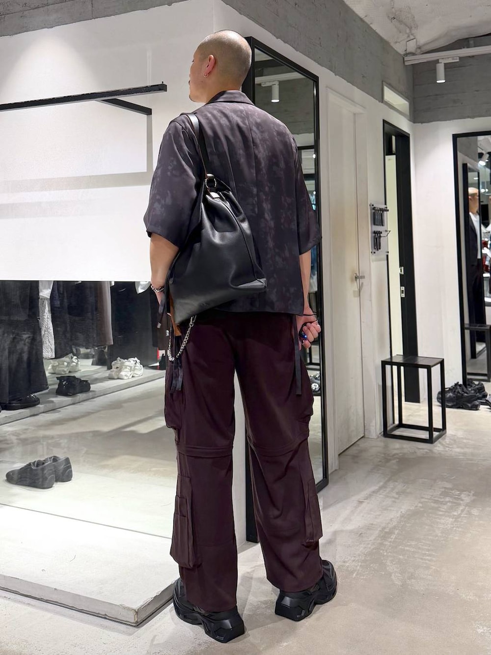 ブラック系のスニーカー、ブラウン系のカーゴパンツ、グレー系のテーラードジャケットを着用したメンズの夏コーディネートの3枚目の写真