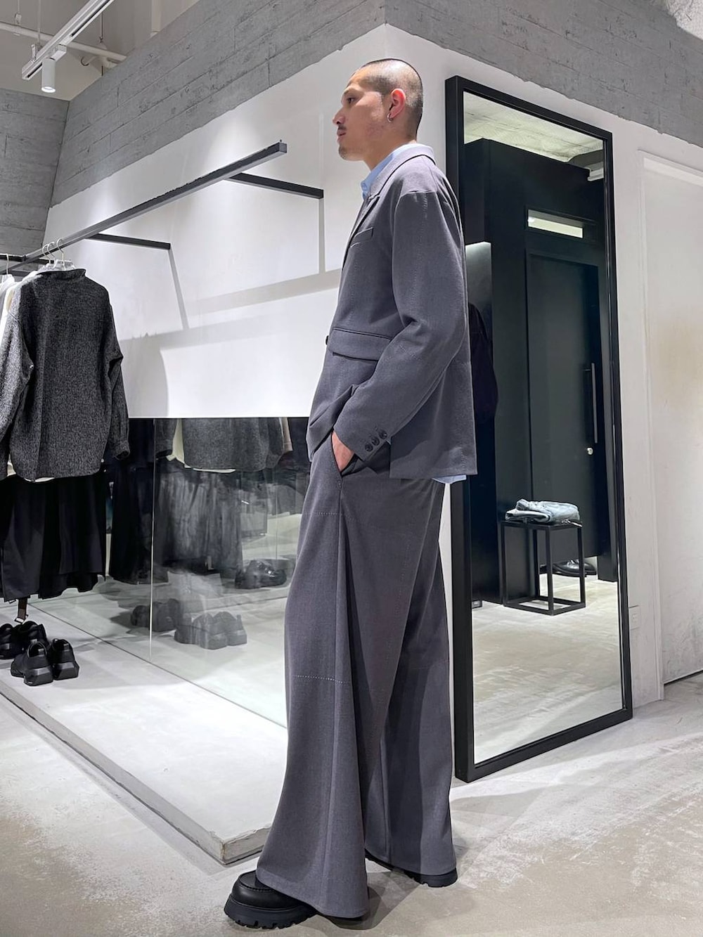 ブラック系のトートバッグ、ブラック系のドレスシューズ、グレー系のテーラードジャケットを着用したメンズの冬コーディネートの2枚目の写真