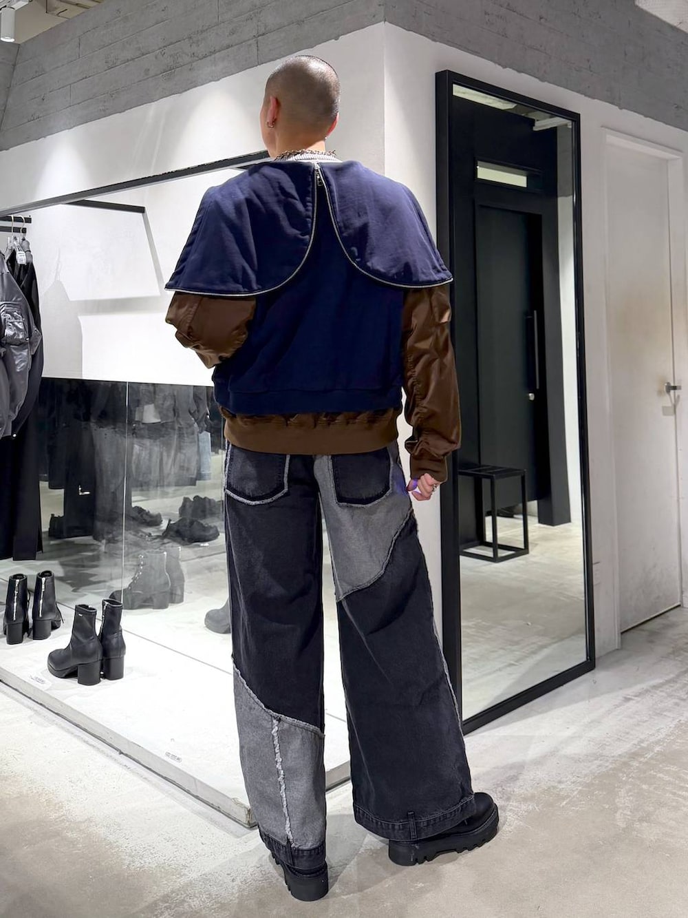 ブラック系のデニムパンツ、ブラック系のドレスシューズ、グレー系のニット/セーターを着用したメンズの冬コーディネートの3枚目の写真