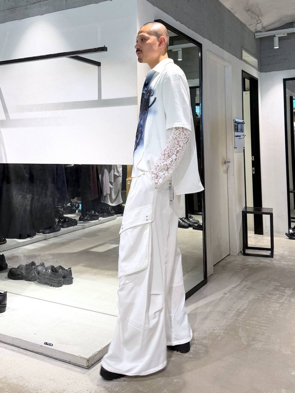 ホワイト系のシャツ/ブラウス、ホワイト系のカーゴパンツ、ブラック系のサンダルを着用したメンズの夏コーディネートの2枚目の写真