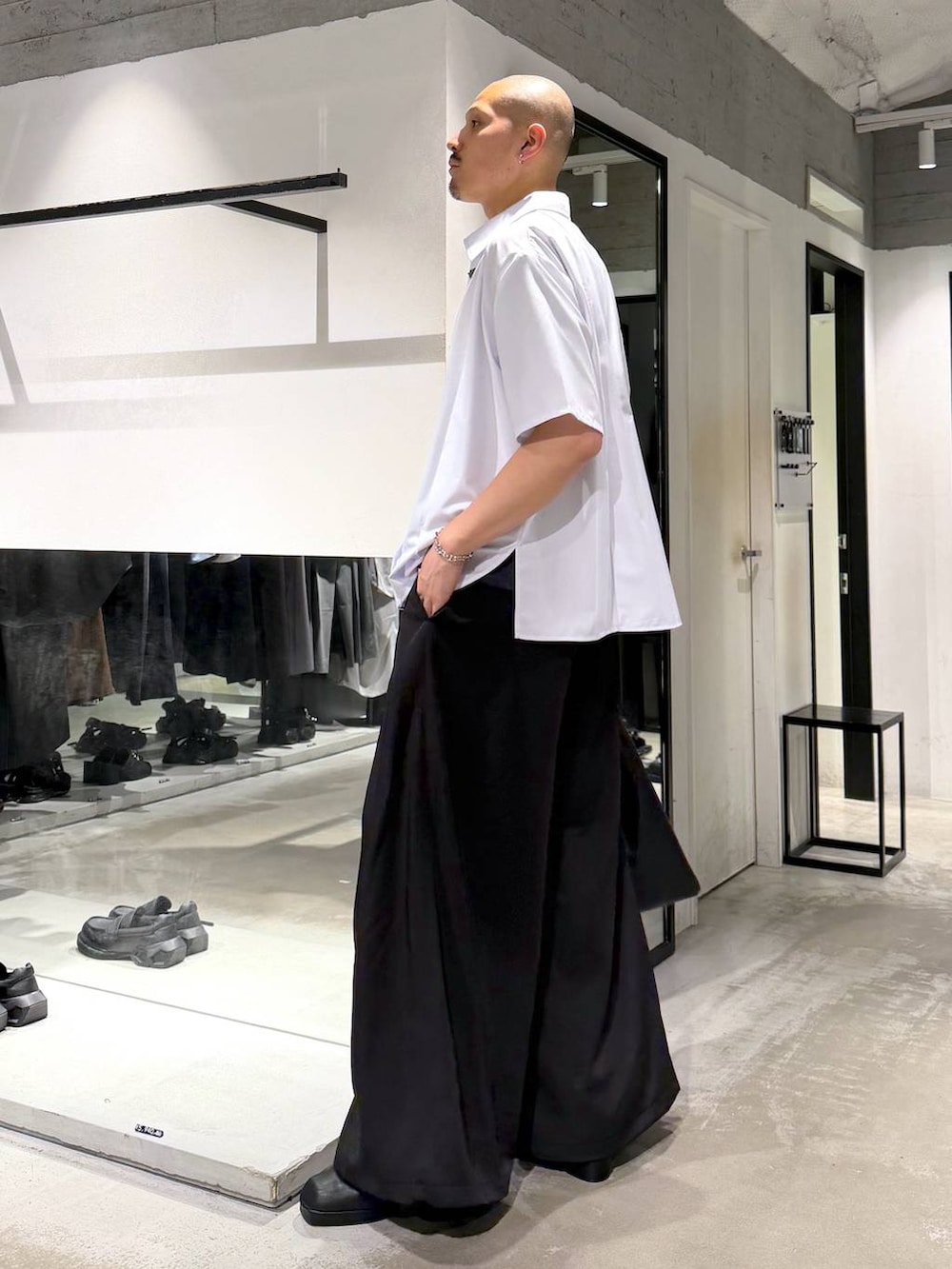 ブラック系のトートバッグ、ブラック系のサンダル、ブルー系のTシャツ/カットソーを着用したメンズの夏コーディネートの2枚目の写真