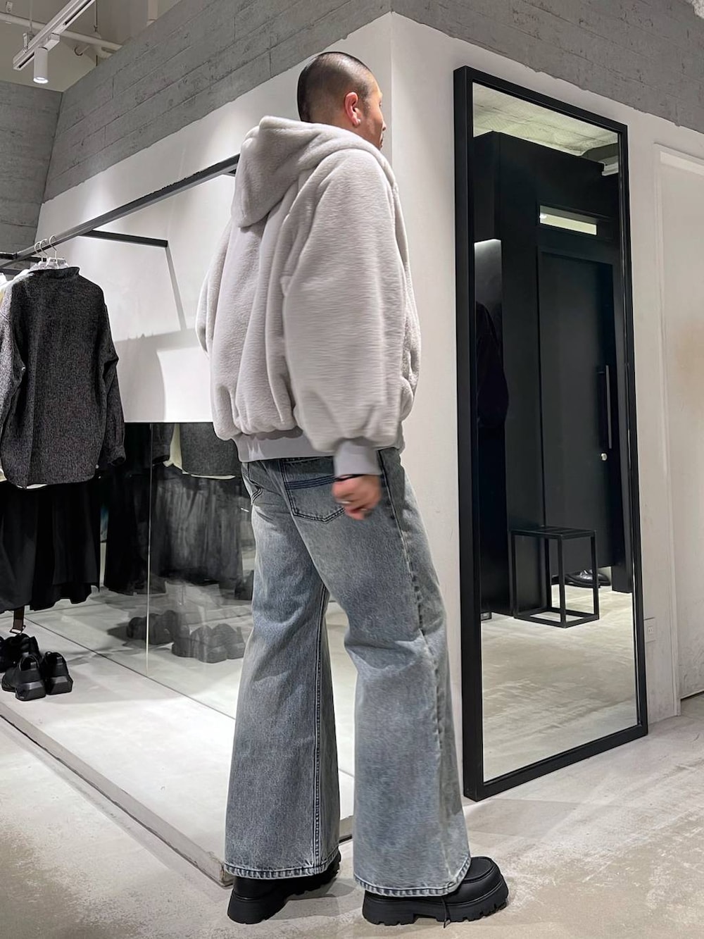 グレー系のブルゾン、ブルー系のデニムパンツ、ブラック系のドレスシューズを着用したメンズの冬コーディネートの4枚目の写真