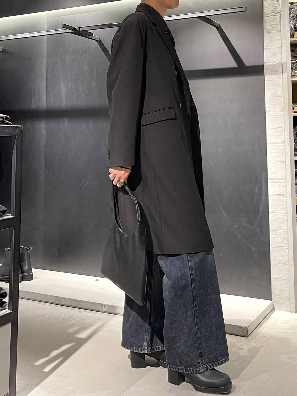 ブラック系のトートバッグ、ブラック系のネクタイ、ブルー系のデニムパンツを着用したメンズの秋コーディネートの4枚目の写真