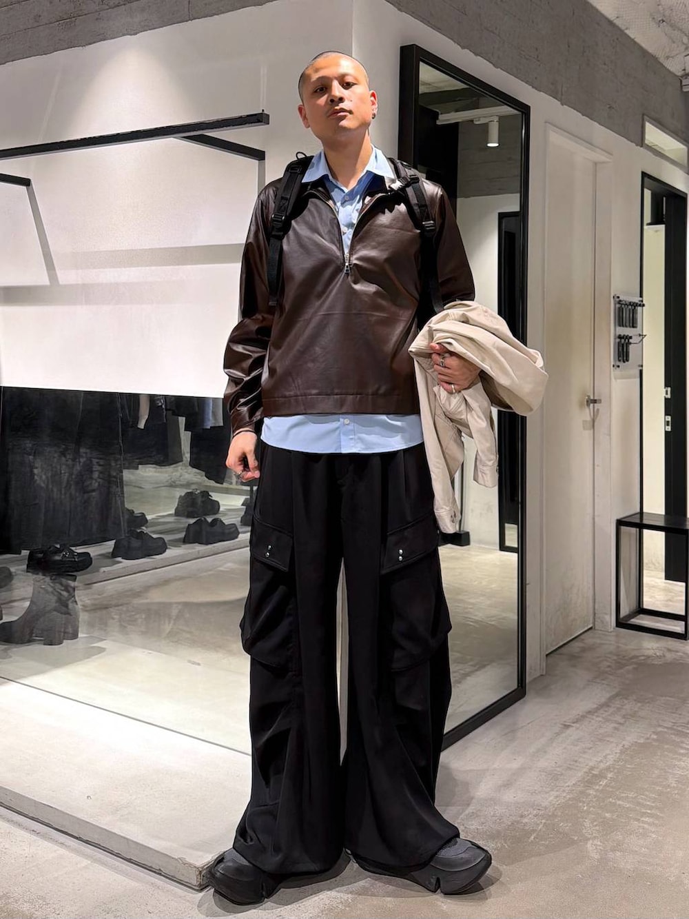 ホワイト系のデニムジャケット、ブラック系のバックパック/リュック、ブラック系のカーゴパンツを着用したメンズの春コーディネートの5枚目の写真