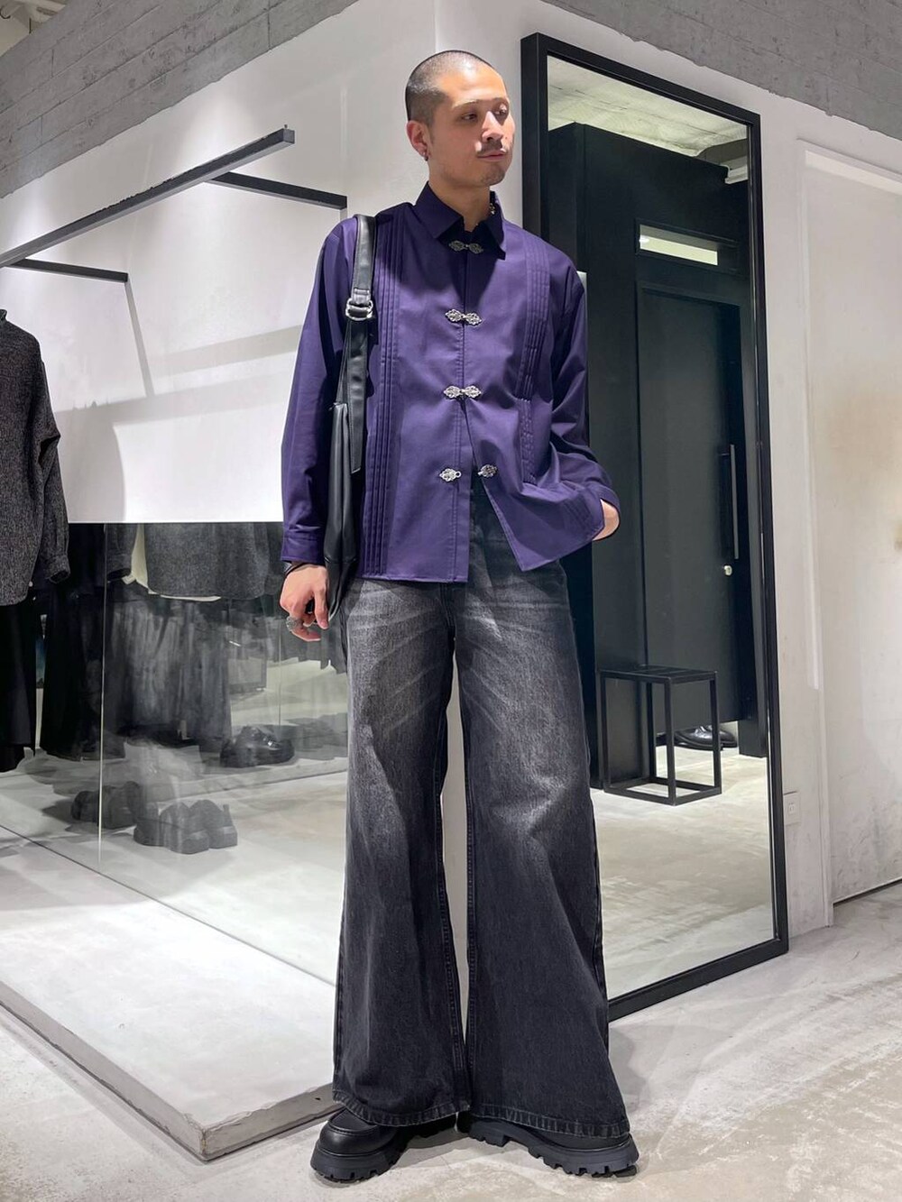 ブラック系のデニムパンツ、ブラック系のドレスシューズ、ブラック系のショルダーバッグを着用したメンズの冬コーディネートの5枚目の写真