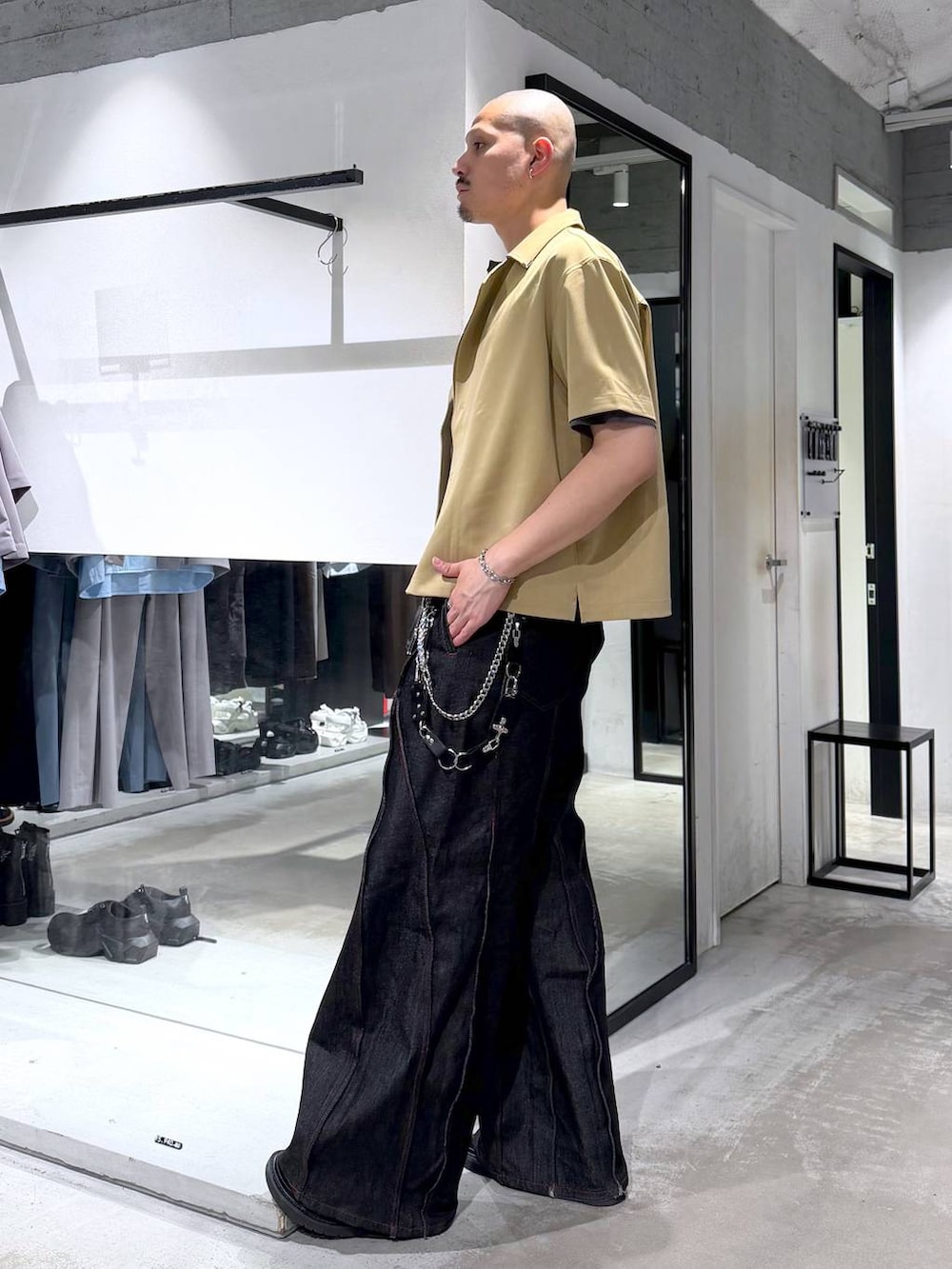 ブラック系のデニムパンツ、ブラック系のサンダル、グレー系のTシャツ/カットソーを着用したメンズの夏コーディネートの2枚目の写真
