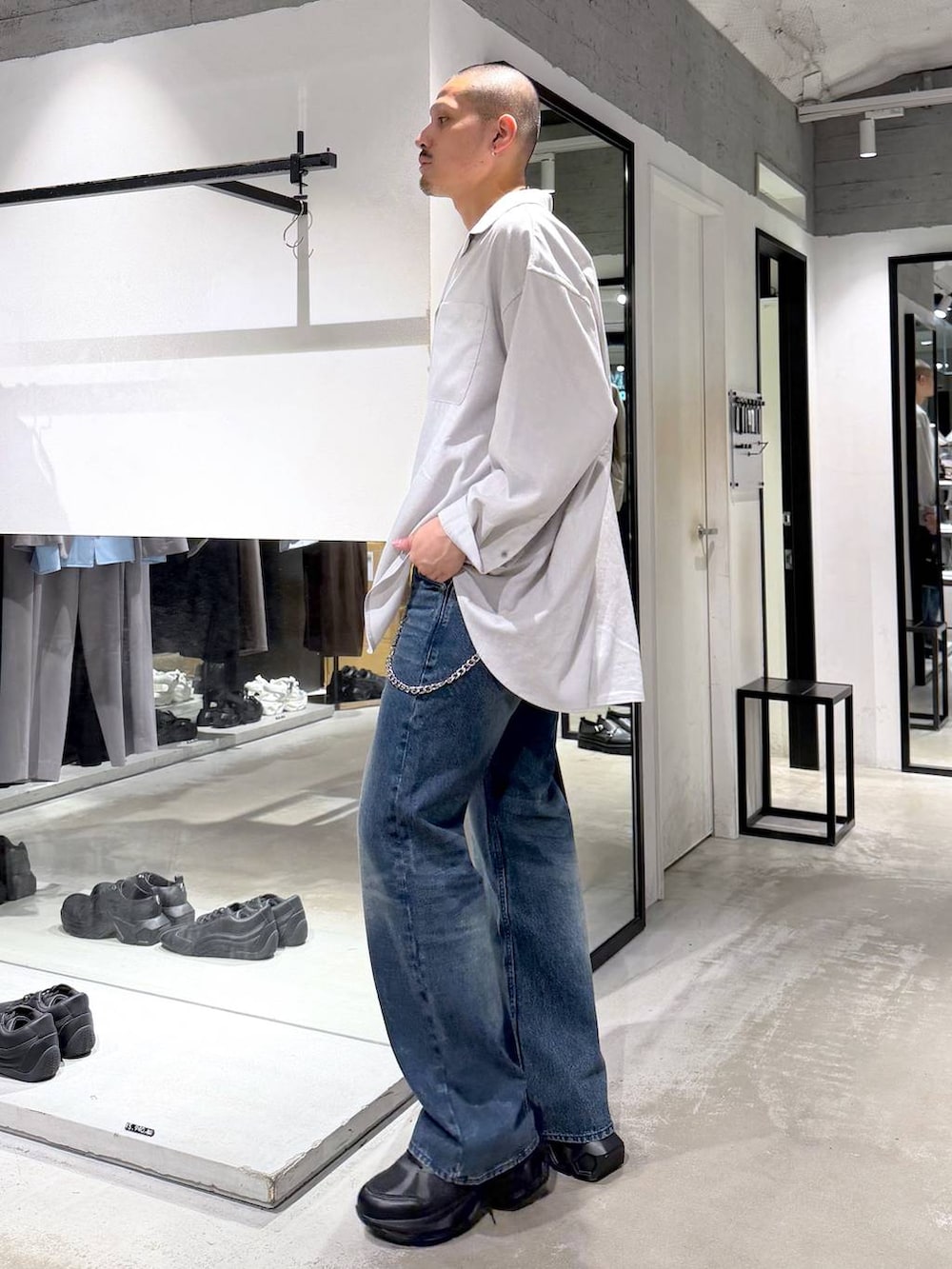 グレー系のシャツ/ブラウス、ブラック系のスニーカー、ブルー系のデニムパンツを着用したメンズの夏コーディネートの2枚目の写真