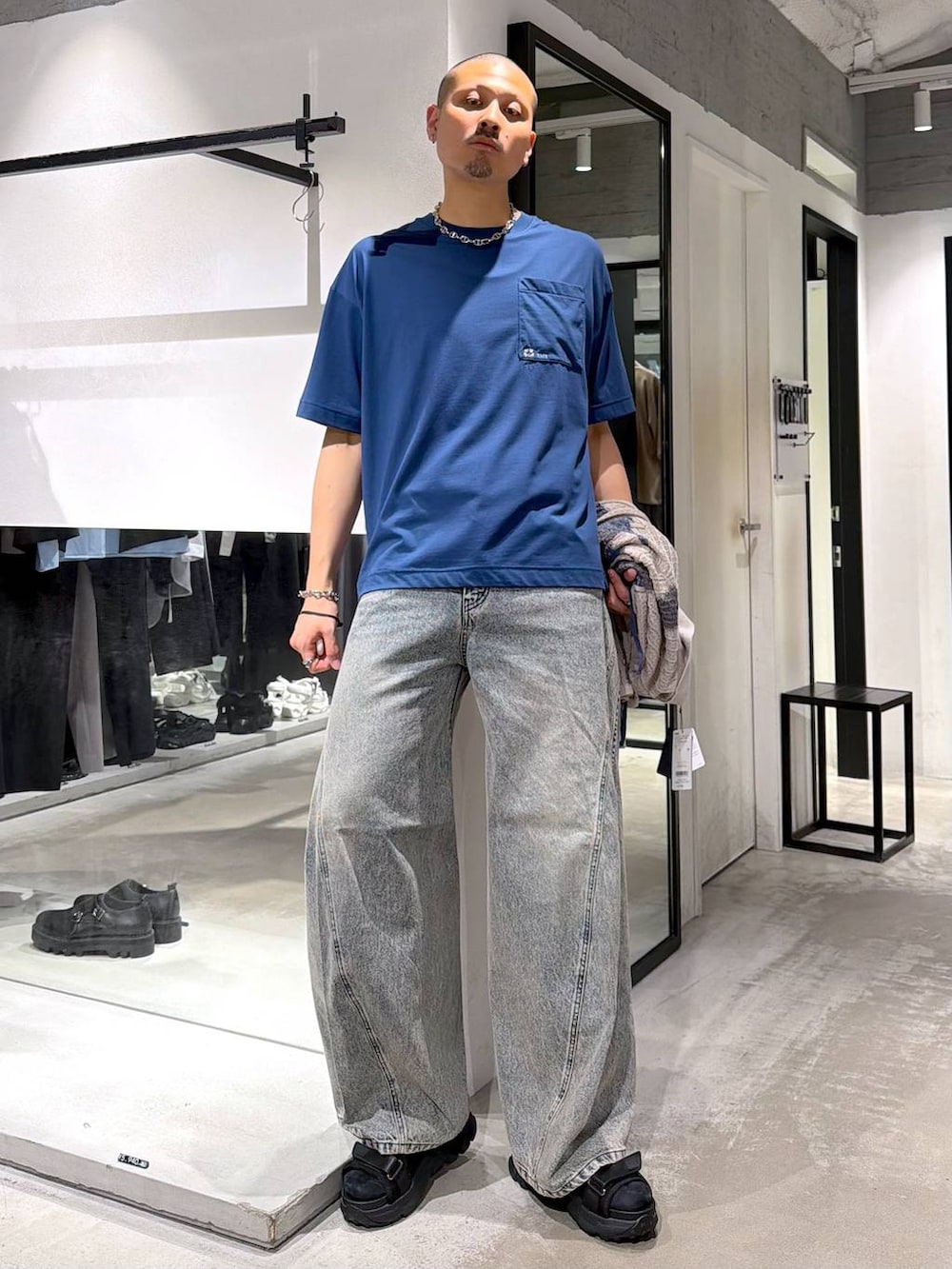 ブルー系のデニムパンツ、ブラック系のサンダル、ブルー系のTシャツ/カットソーを着用したメンズの夏コーディネートの5枚目の写真
