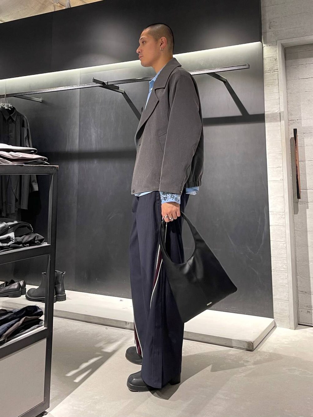 ブラック系のトートバッグ、ブルー系のシャツ/ブラウス、ブラック系のブーツを着用したメンズの秋コーディネートの3枚目の写真