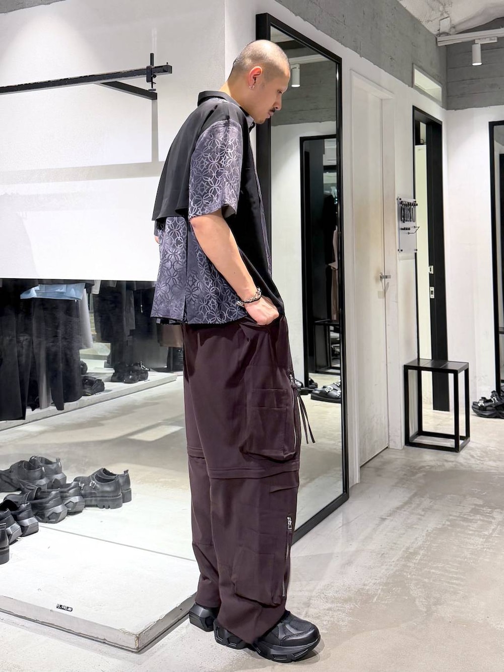 ブラック系のスニーカー、ブラウン系のカーゴパンツ、ブラック系のシャツ/ブラウスを着用したメンズの夏コーディネートの4枚目の写真