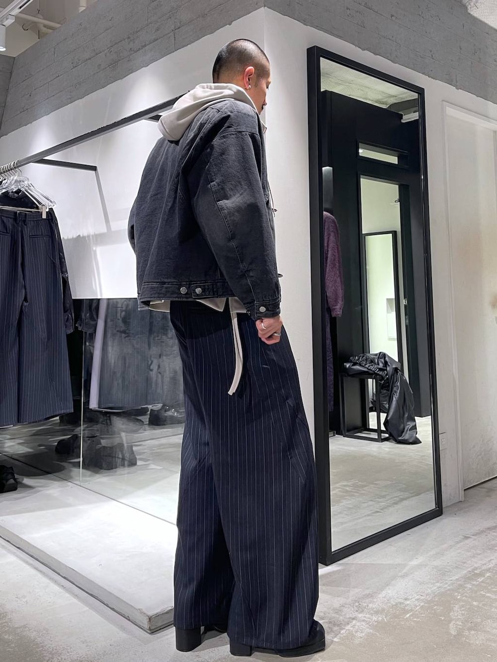 ブルー系のスラックス、ブラック系のブーツ、シルバー系のネックレスを着用したメンズの冬コーディネートの4枚目の写真