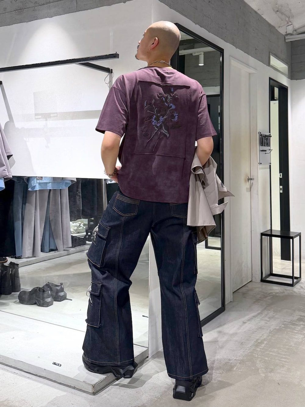 ブラック系のスニーカー、ブルー系のデニムパンツ、ブラック系のトートバッグを着用したメンズの夏コーディネートの5枚目の写真