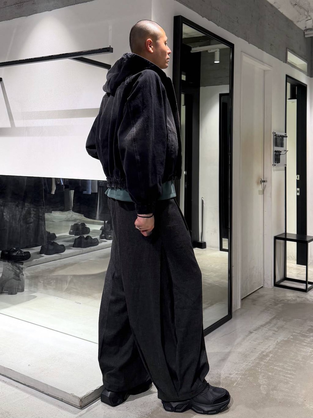 ブラック系のスニーカー、ブラック系のブルゾン、ブラック系のスラックスを着用したメンズの春コーディネートの4枚目の写真