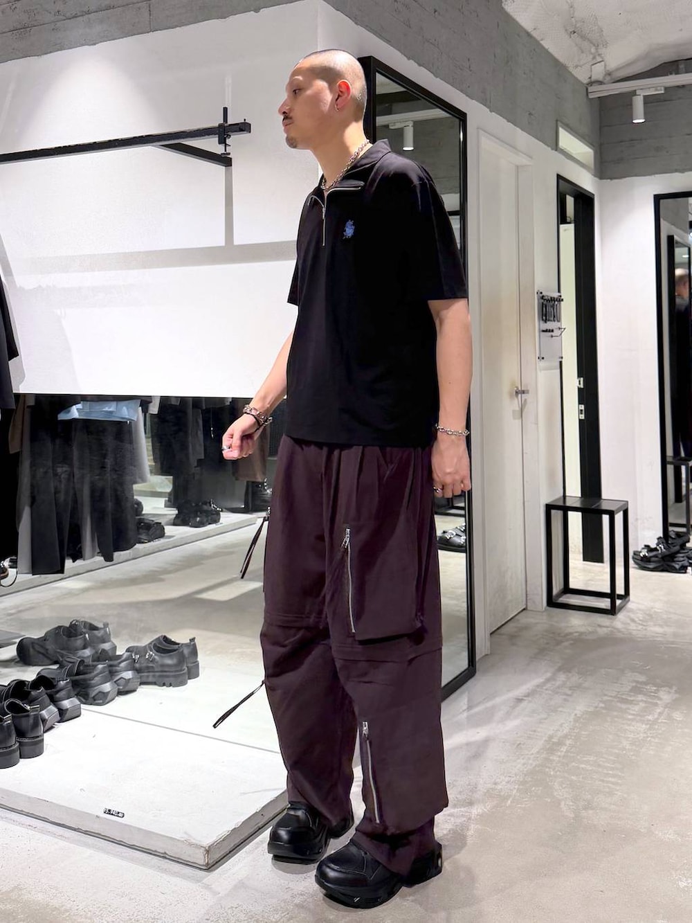 ブラック系のスニーカー、ブラウン系のカーゴパンツ、ブラック系のTシャツ/カットソーを着用したメンズの夏コーディネートの2枚目の写真