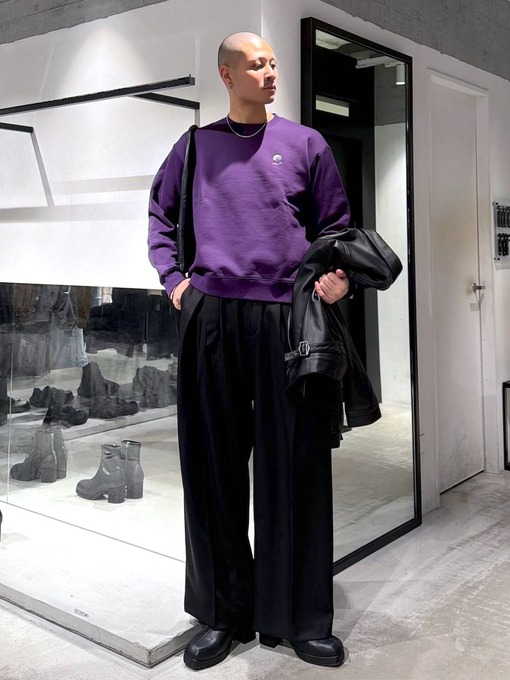 ブラック系のトートバッグ、ブラック系のブーツ、パープル系のスウェットを着用したメンズの冬コーディネートの5枚目の写真