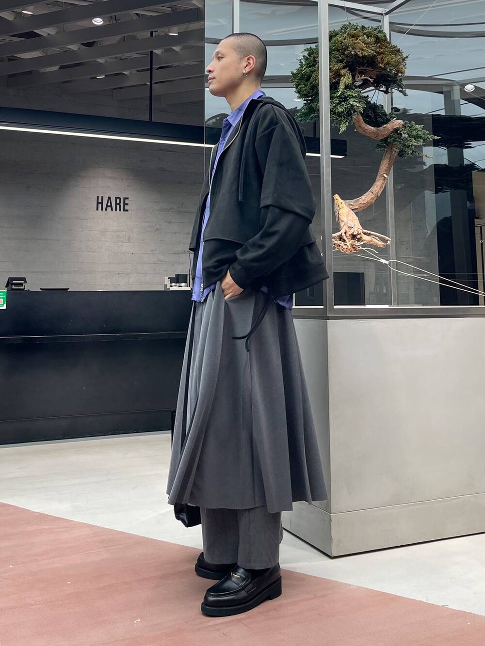 ブラック系のトートバッグ、グレー系のその他パンツ、ブラック系のローファーを着用したメンズの秋コーディネートの2枚目の写真