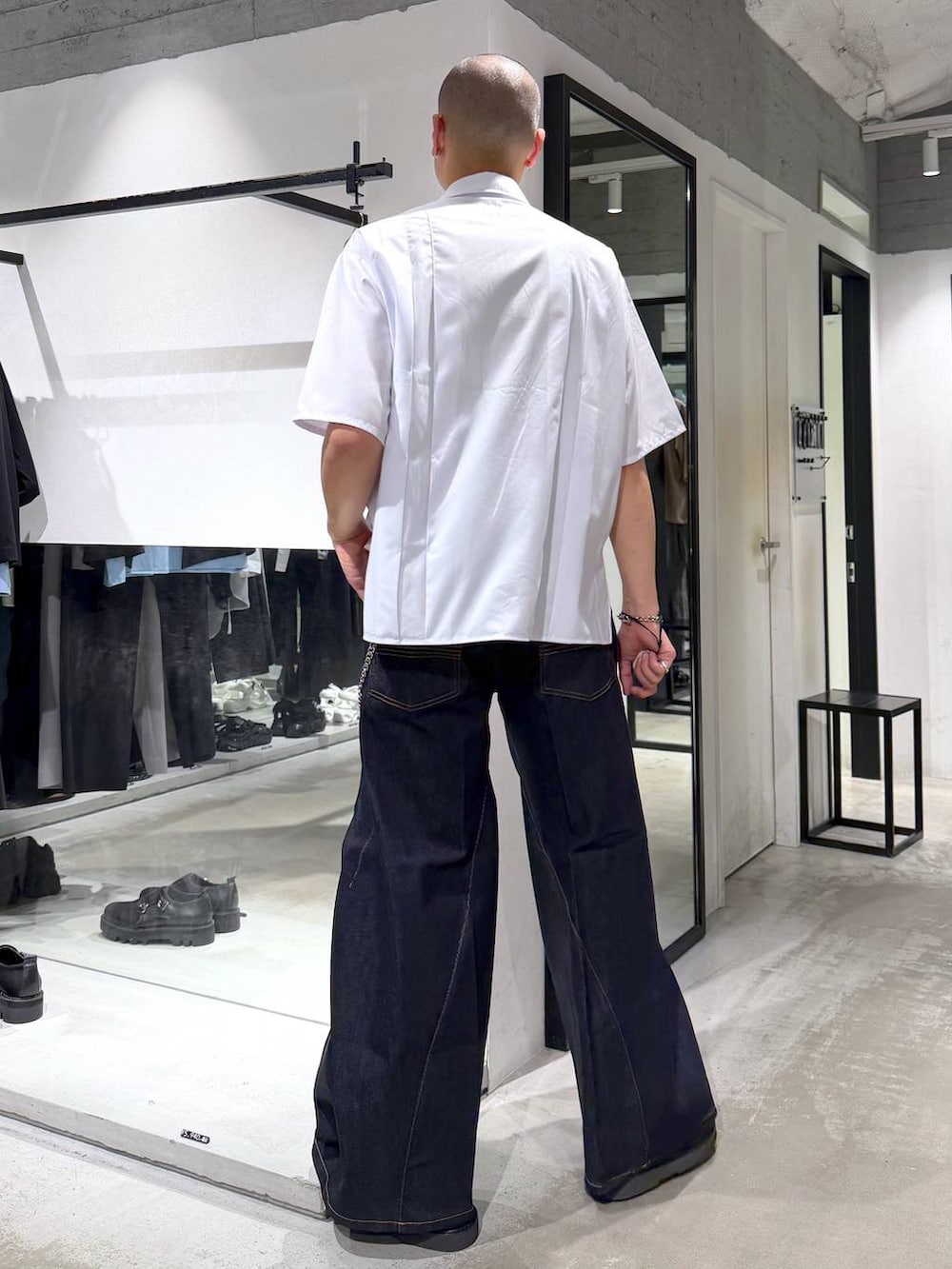 ブルー系のデニムパンツ、ブラック系のサンダル、ホワイト系のシャツ/ブラウスを着用したメンズの夏コーディネートの3枚目の写真