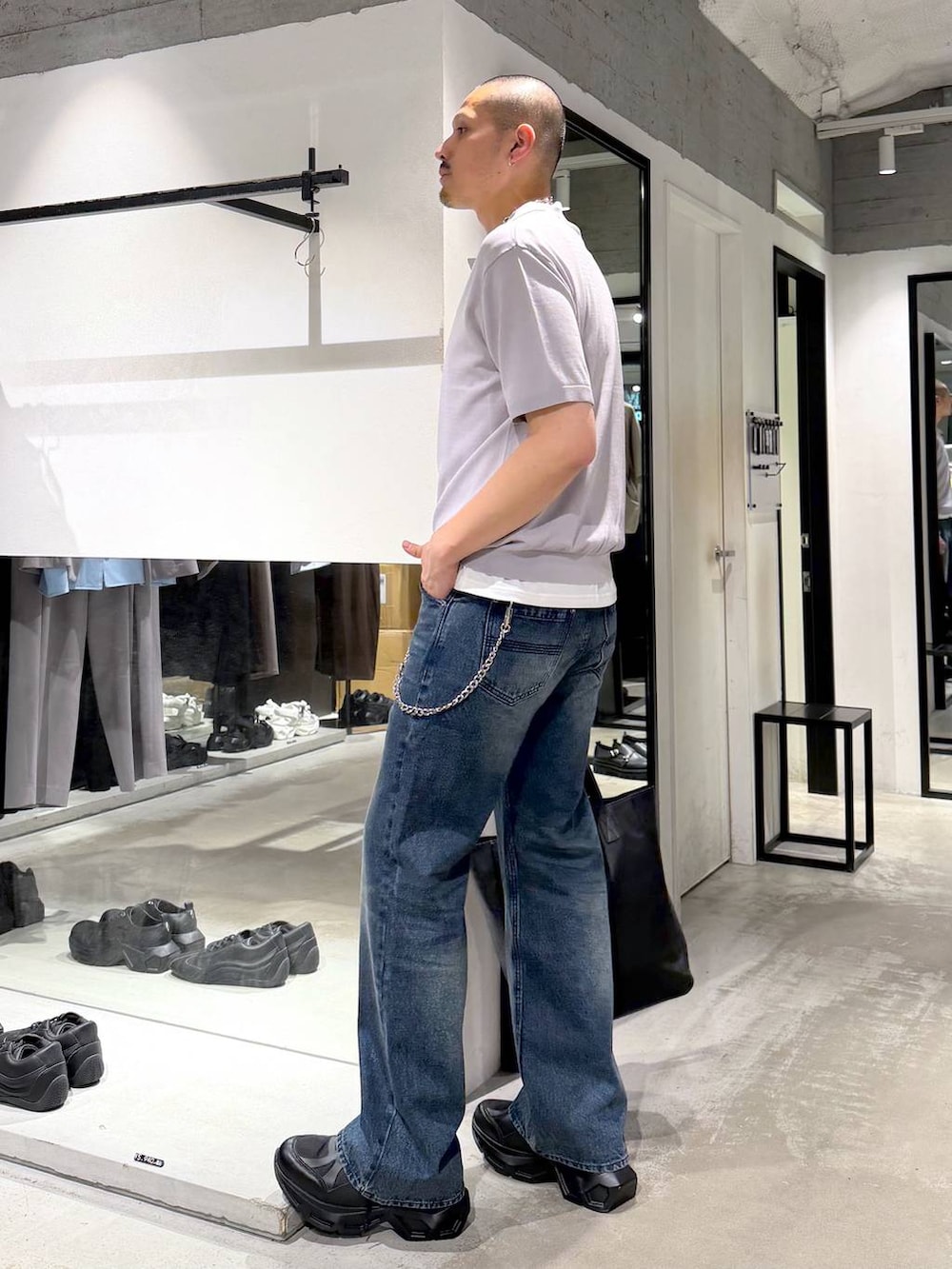 ブラック系のスニーカー、ブラック系のトートバッグ、ブルー系のデニムパンツを着用したメンズの夏コーディネートの2枚目の写真