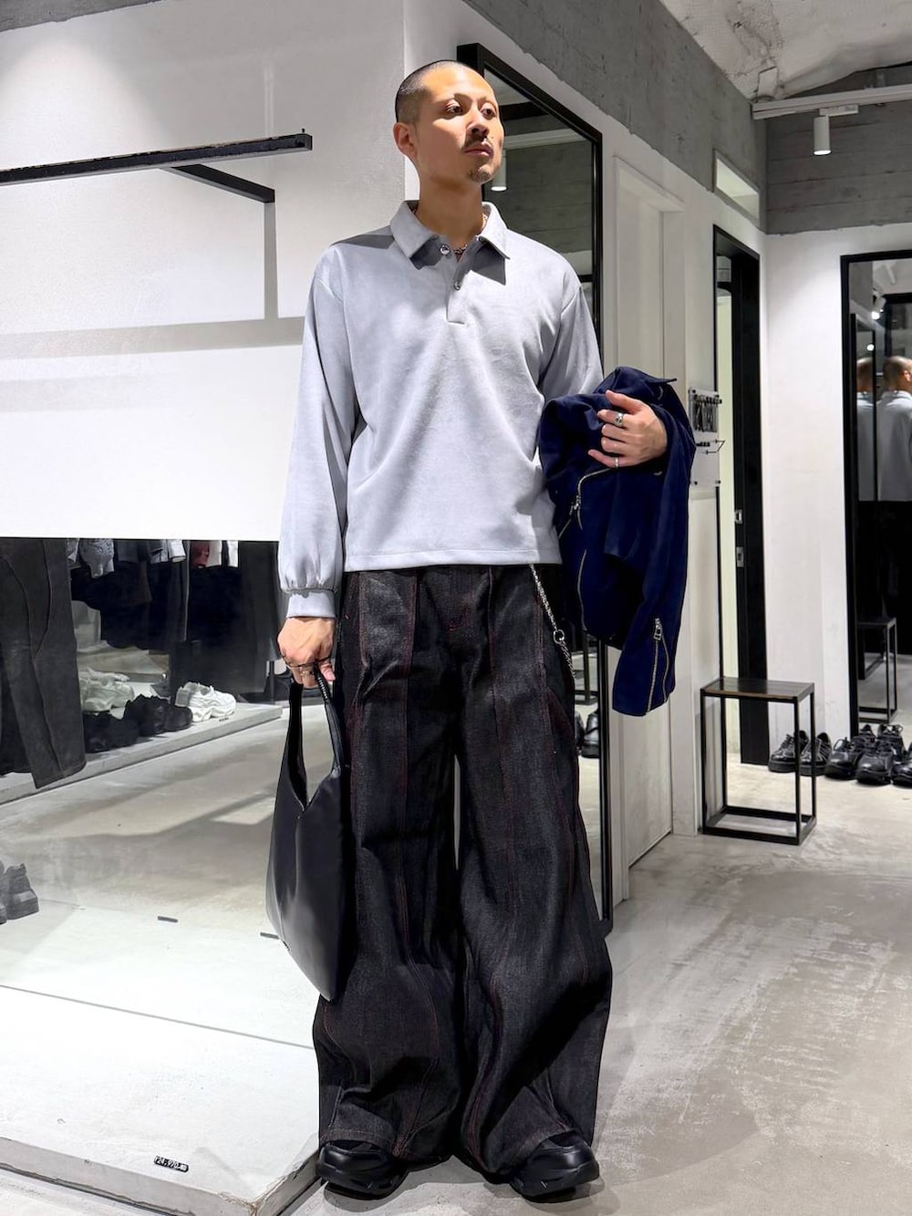 グレー系のTシャツ/カットソー、ブルー系のライダースジャケット、ブラック系のトートバッグを着用したメンズの秋コーディネートの5枚目の写真
