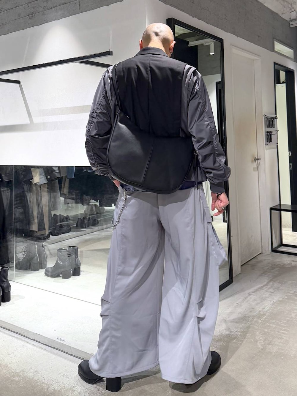 ブラック系のブーツ、ブラック系のショルダーバッグ、ブラック系のテーラードジャケットを着用したメンズの冬コーディネートの3枚目の写真