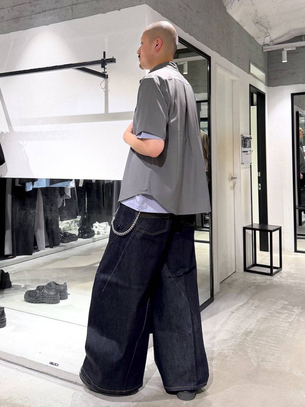 ブルー系のデニムパンツ、ブラック系のサンダル、パープル系のTシャツ/カットソーを着用したメンズの夏コーディネートの2枚目の写真