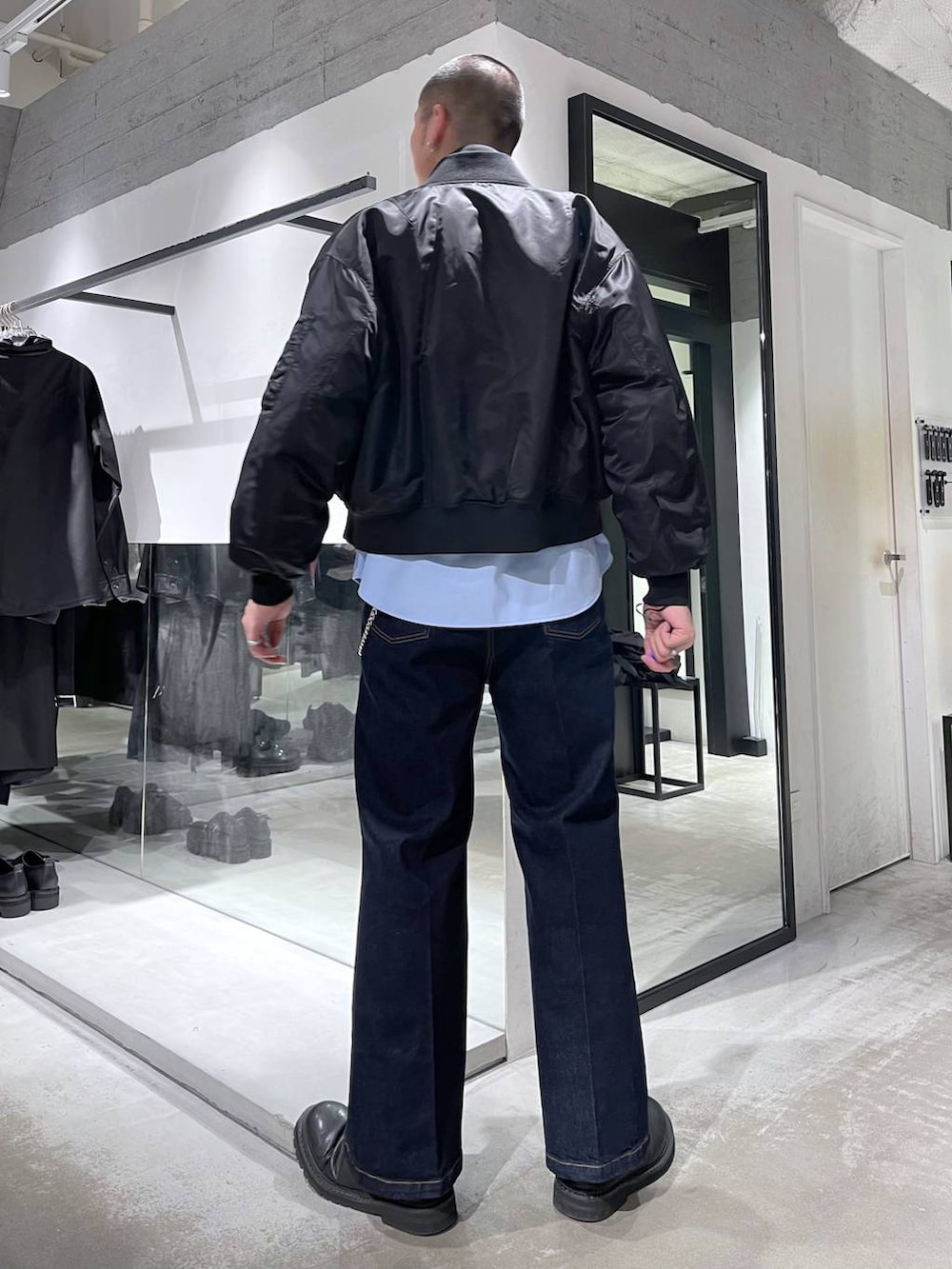 ブルー系のネクタイ、ブラック系のMA-1、ブルー系のデニムパンツを着用したメンズの冬コーディネートの3枚目の写真