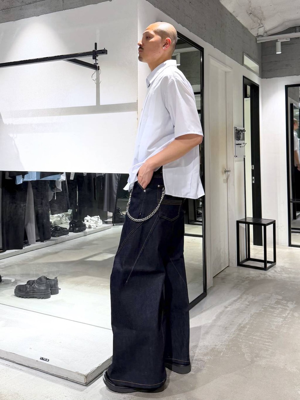 ブルー系のデニムパンツ、ブラック系のサンダル、ホワイト系のシャツ/ブラウスを着用したメンズの夏コーディネートの2枚目の写真