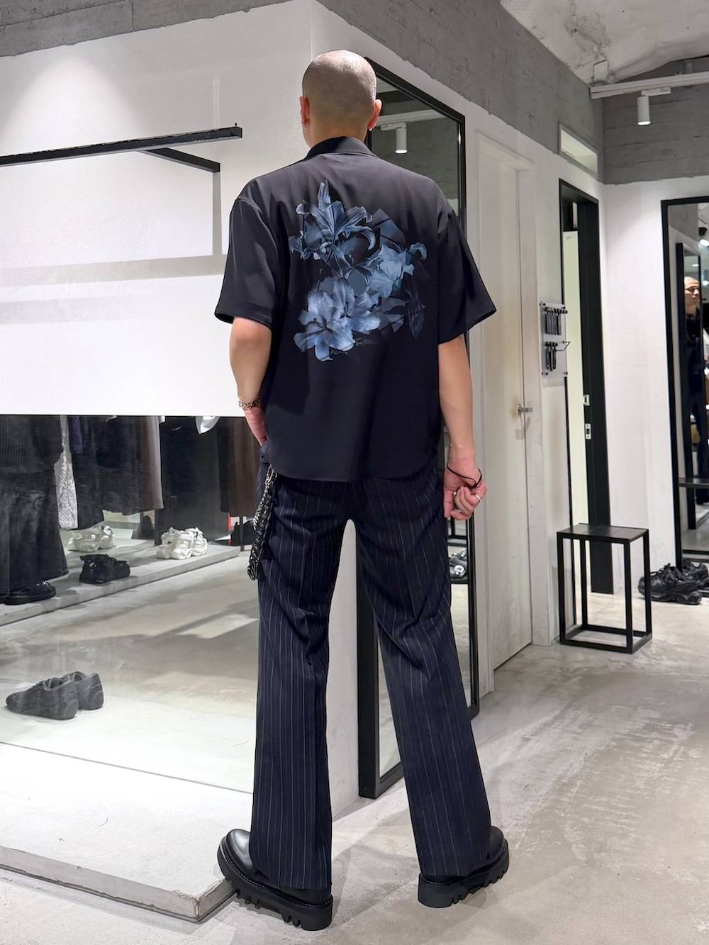 ブルー系のスラックス、ブラック系のドレスシューズ、ブルー系のTシャツ/カットソーを着用したメンズの夏コーディネートの3枚目の写真