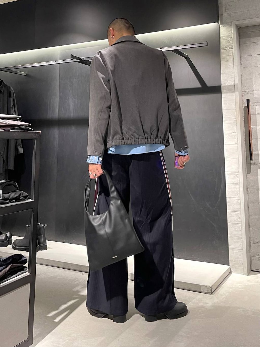 ブラック系のトートバッグ、ブルー系のシャツ/ブラウス、ブラック系のブーツを着用したメンズの秋コーディネートの4枚目の写真