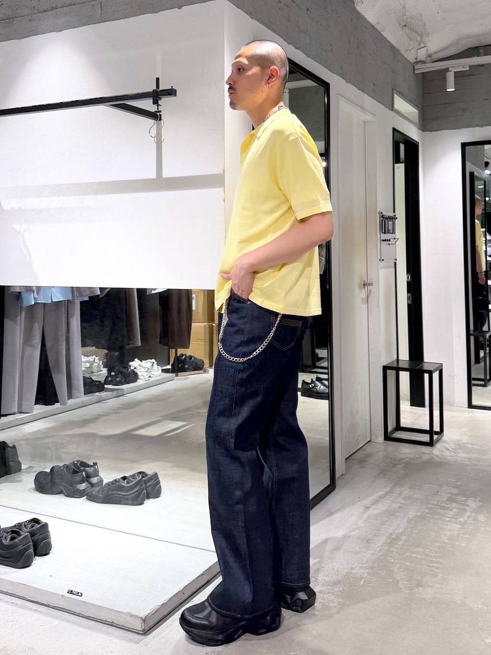 ブラック系のスニーカー、ホワイト系のTシャツ/カットソー、ブラック系のデニムパンツを着用したメンズの夏コーディネートの2枚目の写真
