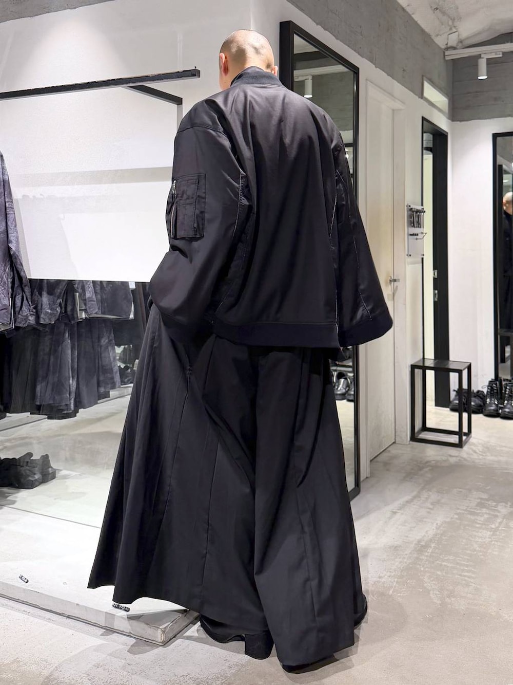 ブラック系のブルゾン、ブラック系のTシャツ/カットソー、ブラック系のブーツを着用したメンズの秋コーディネートの3枚目の写真