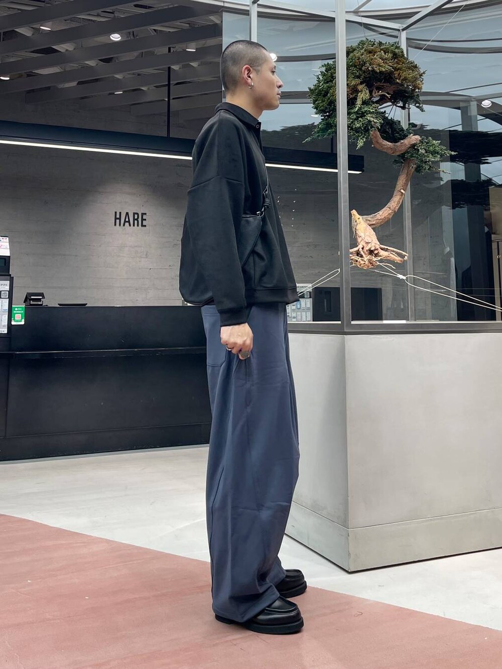 ブラック系のローファー、ブルー系のスウェットパンツ、ブラック系のショルダーバッグを着用したメンズの秋コーディネートの4枚目の写真